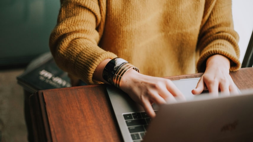 5 Tips to Sell Mugs Successfully on Etsy A person typing on a laptop.