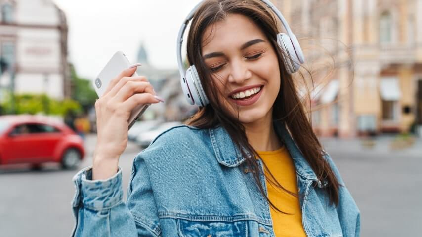 A woman smiling and wearing headphones.