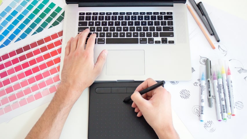 Design Like a Pro Even if You re Not A person typing on a laptop and drawing on a tablet.