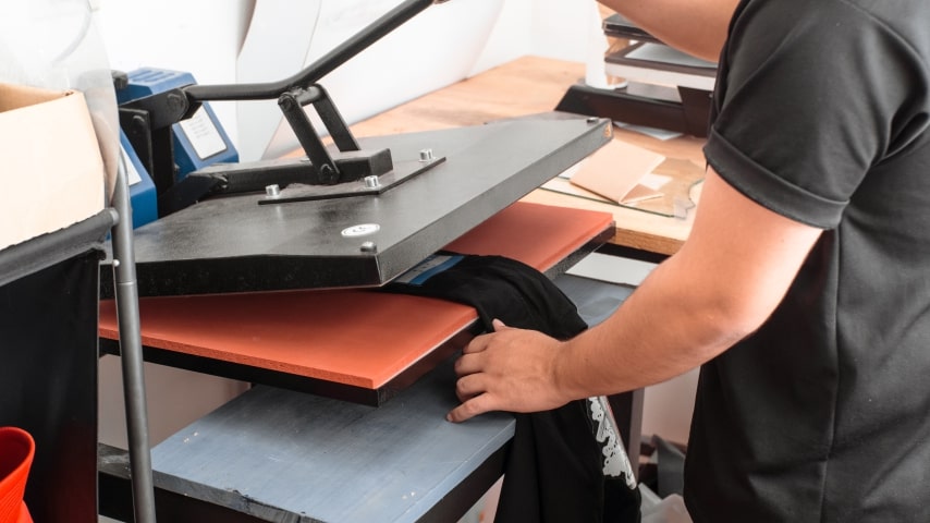 How Does Sublimation Printing Work A person using a heat press to sublimate a garment.