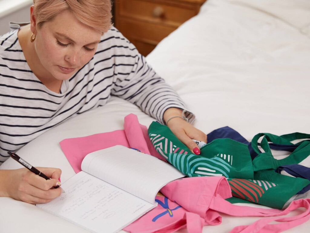 A woman checking the quality of custom tote bag samples.