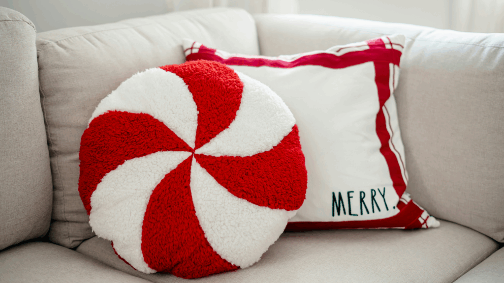 Chateaucore A red and white pillow featuring a decorative Christmas candy cane design.