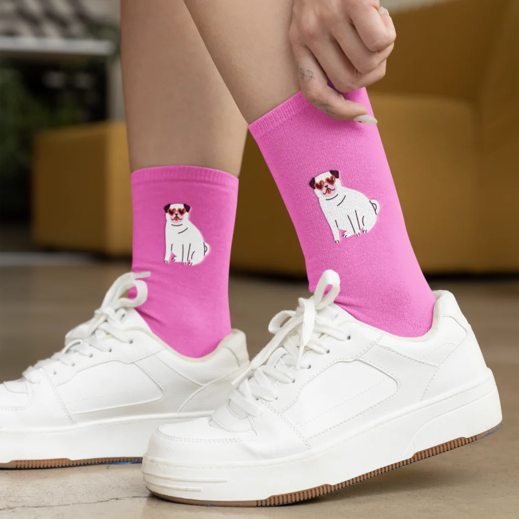 A woman wearing white shoes and custom pink socks with a dog illustration print.