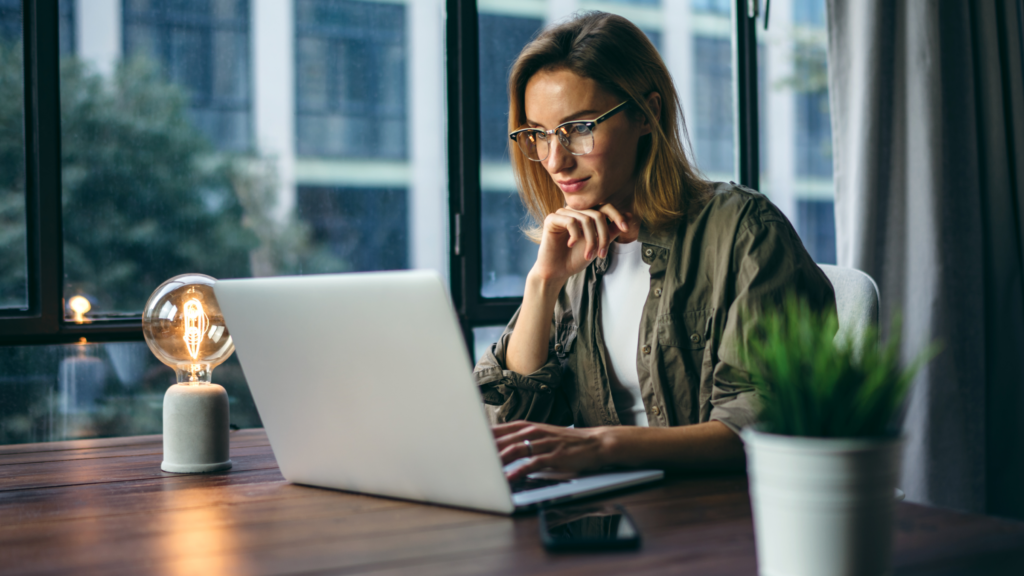 A woman sitting in front of a laptop at the table.