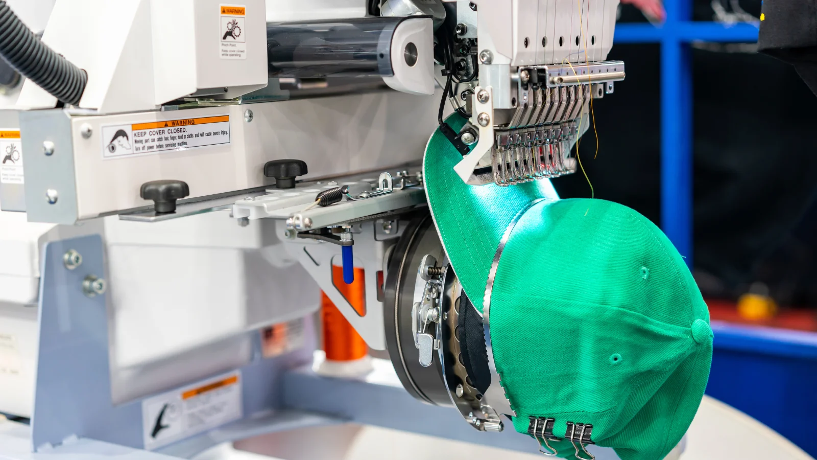 Embroidery Types of shirt printing A green hat being embroidered with a logo.