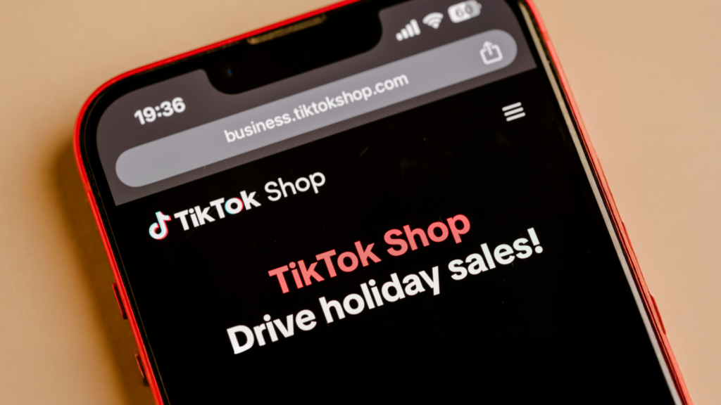 Close-up of a smartphone screen displaying the TikTok Shop website with the message "Drive holiday sales!".